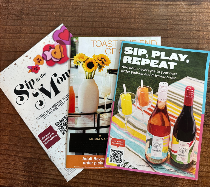Target Adult Beverage booklets lay flat along a wood grain background
